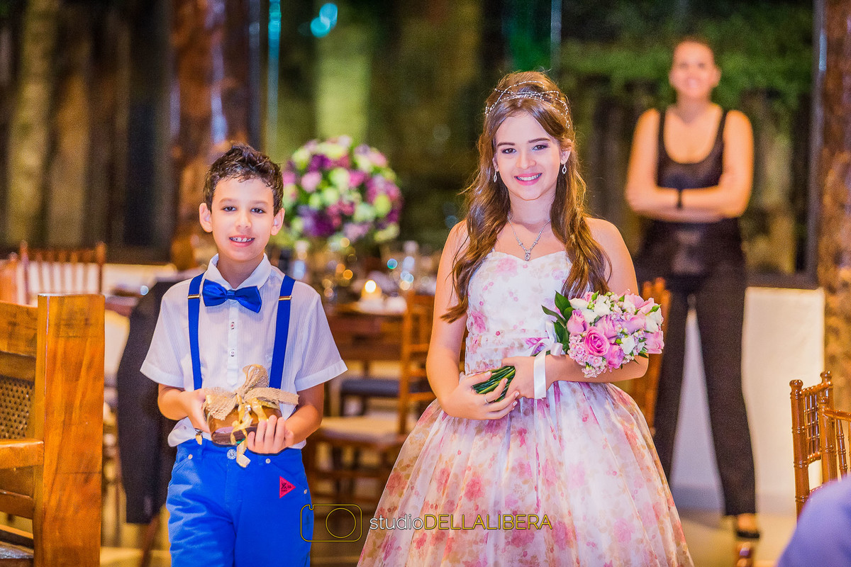 Noivinhos entrando segurando a aliança e um buque de rosas