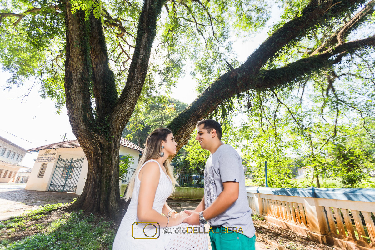 Noiva sentada de frente para o noivo olhando nos olhos dele e segurando suas mãos sorrindo