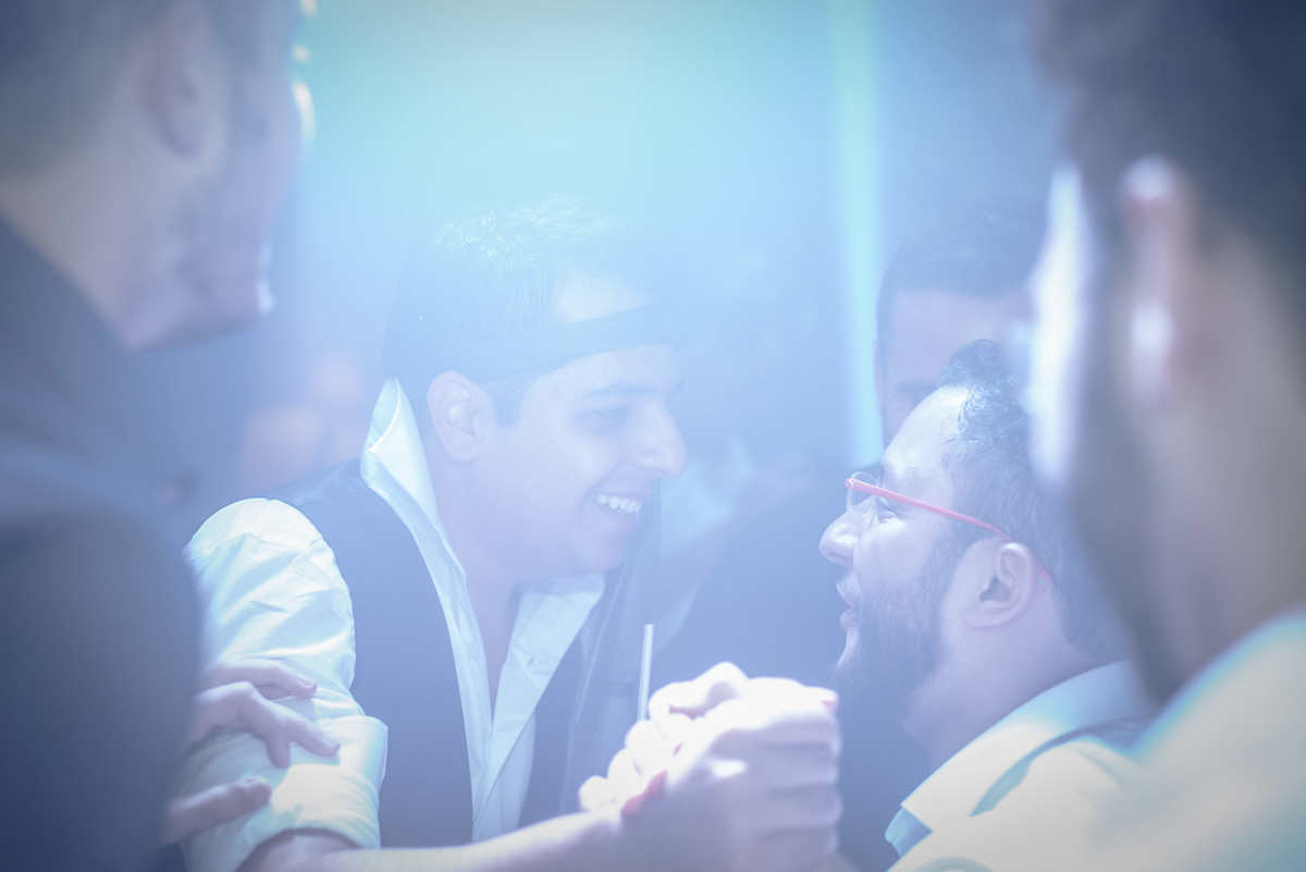 Noivo cumprimentando um amigo enquanto curte a pista de dança