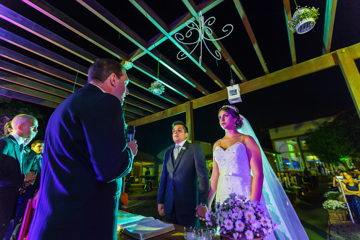 Padre começando a cerimônia com noivos de mãos dadas