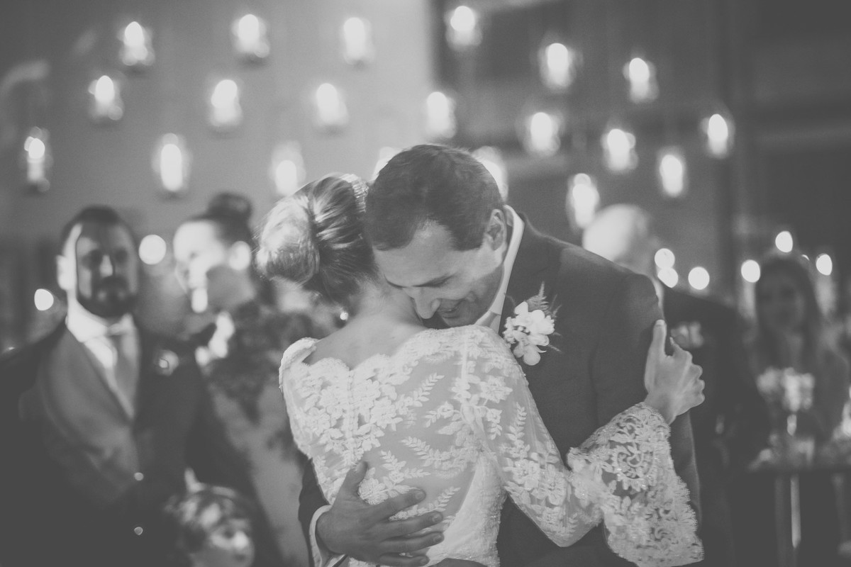 Noivo segurando a noiva enquanto eles dançam a valsa na festa