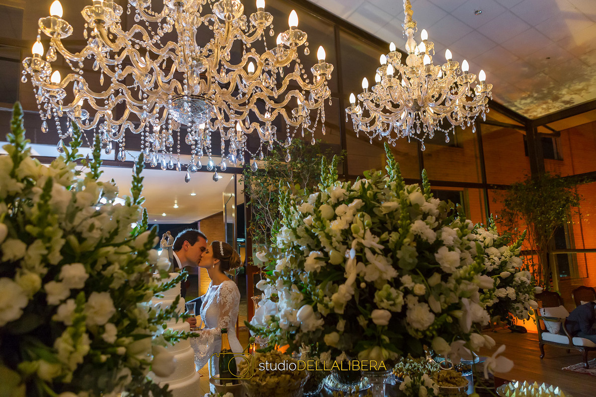 Noivos se beijando na mesa do bolo