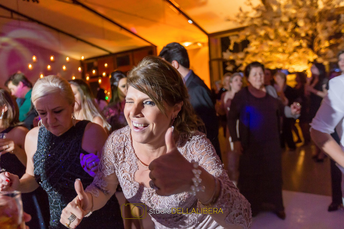 Mãe da noiva curtindo muito a festa na pista de dança sorrindo e fazendo
