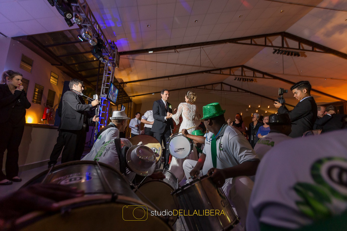 Noivos dançando e o bateria da escola de samba olhando para eles descer até o chão