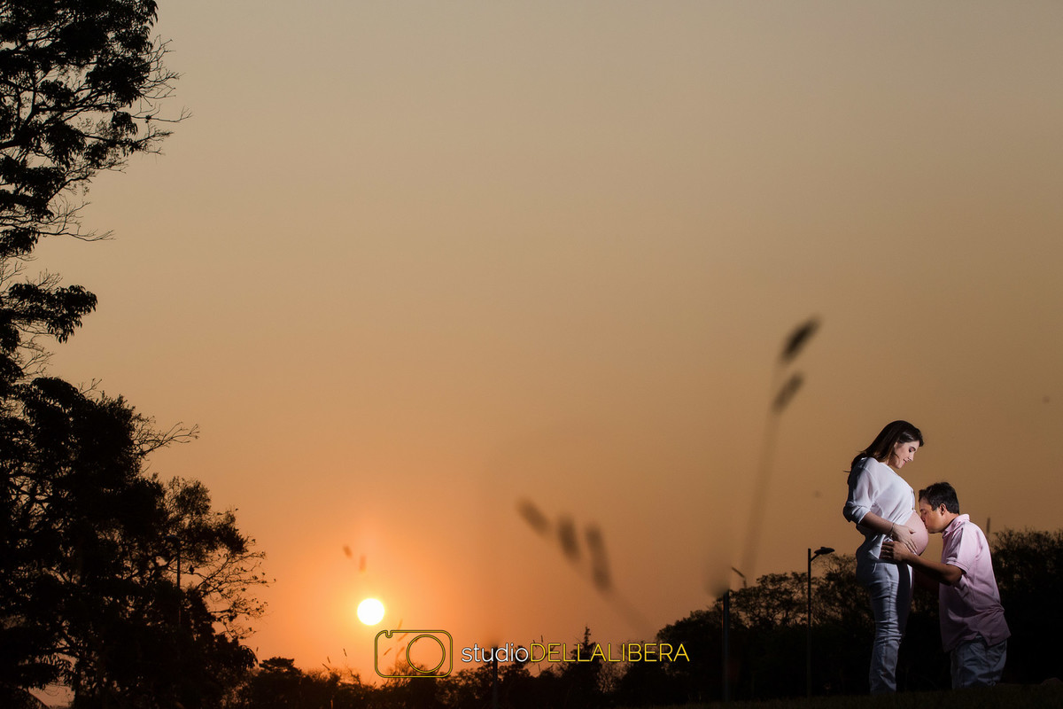 sessão fotografica gestante Piracicaba pai beijando a barriga da mãe em um final de tarde fantastico