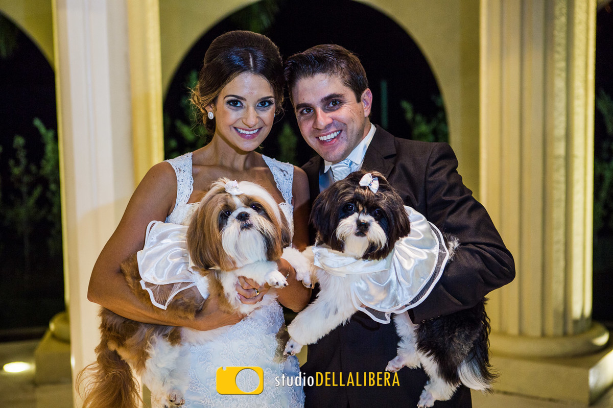 noivos fazendo sessão de fotos com os cachorros após casamento