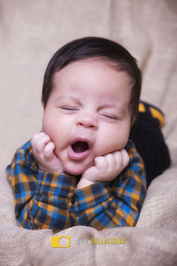 Sessão newborn bebê com a mão no queixo de boca aberta
