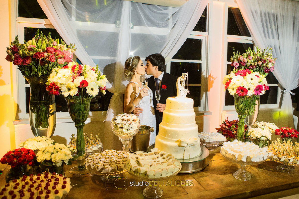 Corte do bolo com noivos se beijando