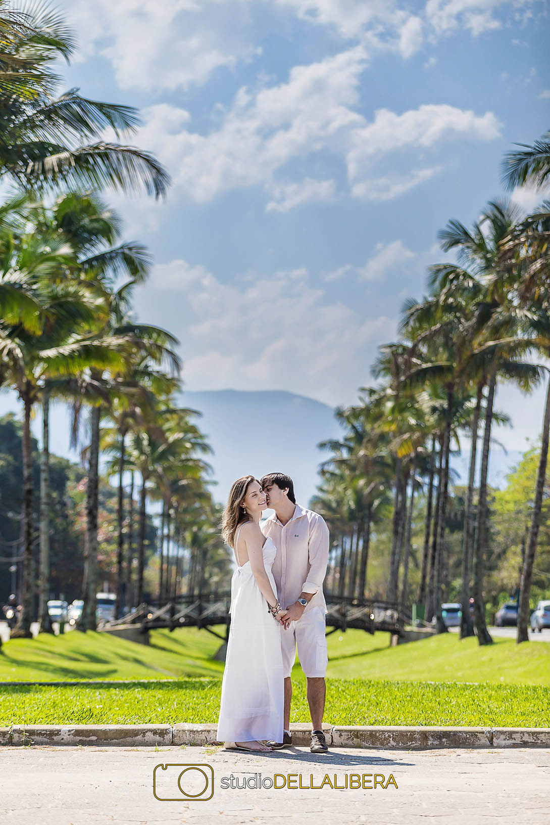 Casal em meio a fileira de coqueiros , na sessão de fotos pre casamento na Riviera de São Lourenço