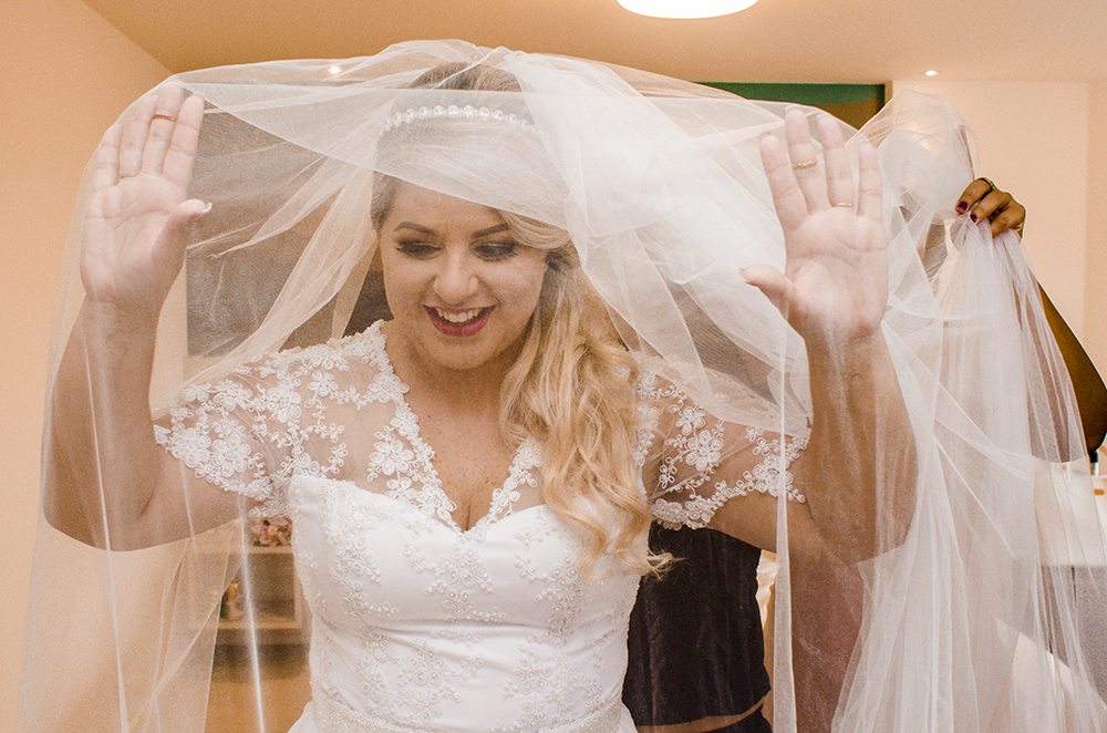 nossa casa estúdio making of noiva se olhando no espelho e sorri batom casamento em niterói