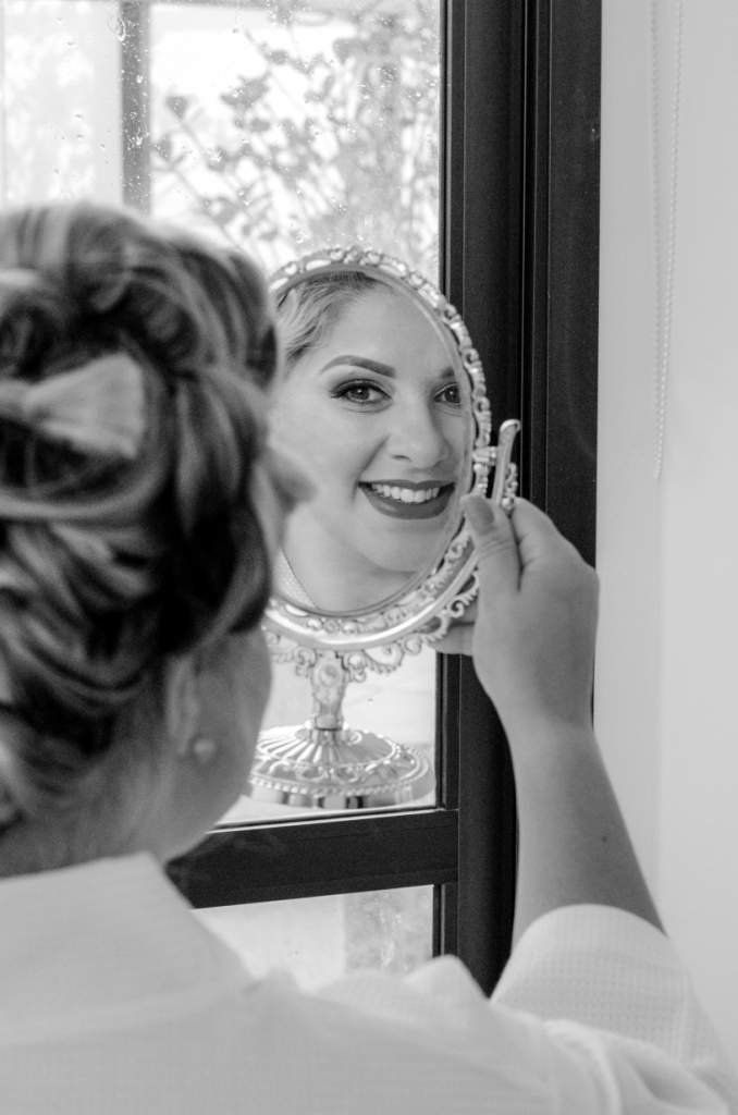 nossa casa estúdio making of noiva se olhando no espelho e sorri batom casamento em niterói