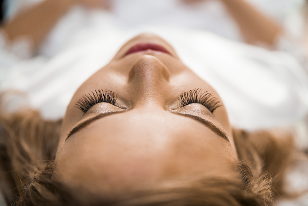 nossa casa estudio making of da noiva maquiagem profissional  no dia do casamento deitada de olhos fechados com batom vermelho casamento em cabo frio