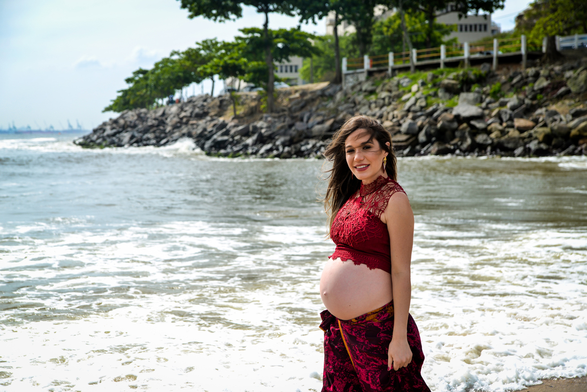 Ensaio fotográfico profissional gestante em niterói Nossa Casa Estúdio na praia
de boa viagem no por do sol com saia longa e top vermelho
mar calmo gestação gravidez mãe de primeira viagem
com marido casal rio de janeiro primavera verão vestido maquiagem