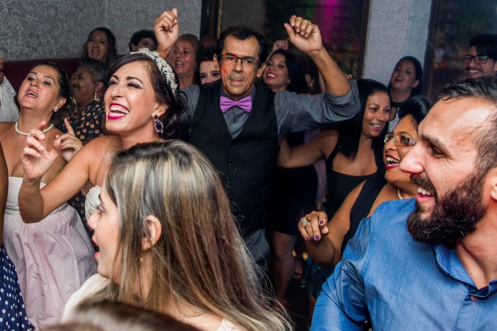 Nossa Casa Estúdio Gilson Freitas Fotógrafo profissional de casamentos fotografia de matrimônio em Niterói Rio de Janeiro com vestido branco e noivo casal na pista de dança e convidados dançando DJ Iluminação espaço Dimattoni felizes Noiva 