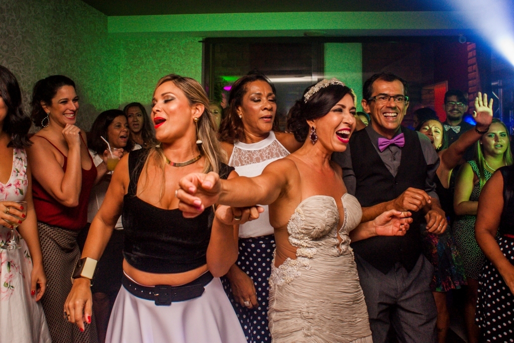 Nossa Casa Estúdio Gilson Freitas Fotógrafo profissional de casamentos fotografia de matrimônio em Niterói Rio de Janeiro com vestido branco e noivo casal na pista de dança e convidados dançando DJ Iluminação espaço Dimattoni felizes Noiva 