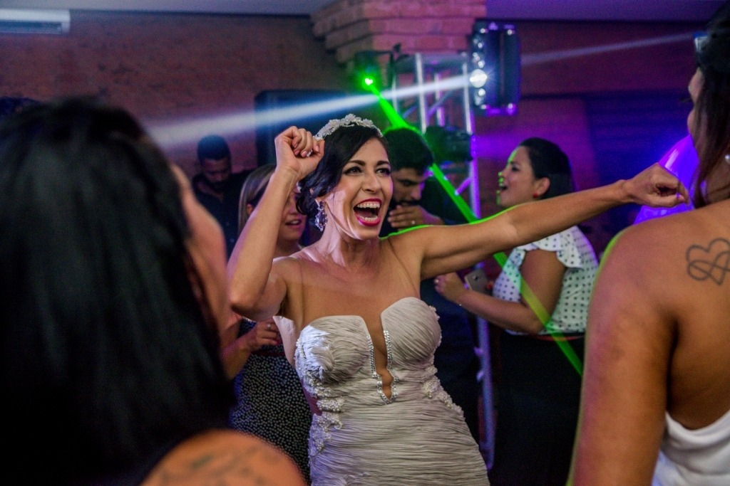 Nossa Casa Estúdio Gilson Freitas Fotógrafo profissional de casamentos fotografia de matrimônio em Niterói Rio de Janeiro com vestido branco e noivo casal na pista de dança e convidados dançando DJ Iluminação espaço Dimattoni felizes Noiva 