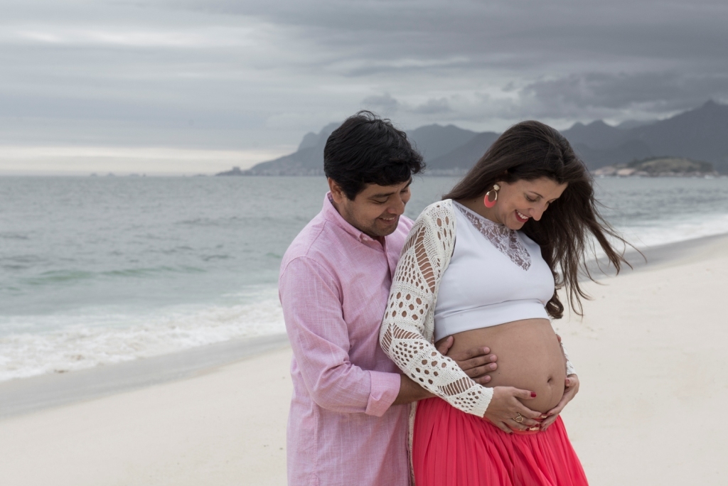 Ensaio fotográfico profissional externo e estúdio de gestante de dia em Niterói Rio de Janeiro na praia de Piratininga em dia chuvoso na areia grávida papai e mamãe com bebê a bordo book de fotos litoral Gilson Freitas fotógrafo vestido e roupa top branco