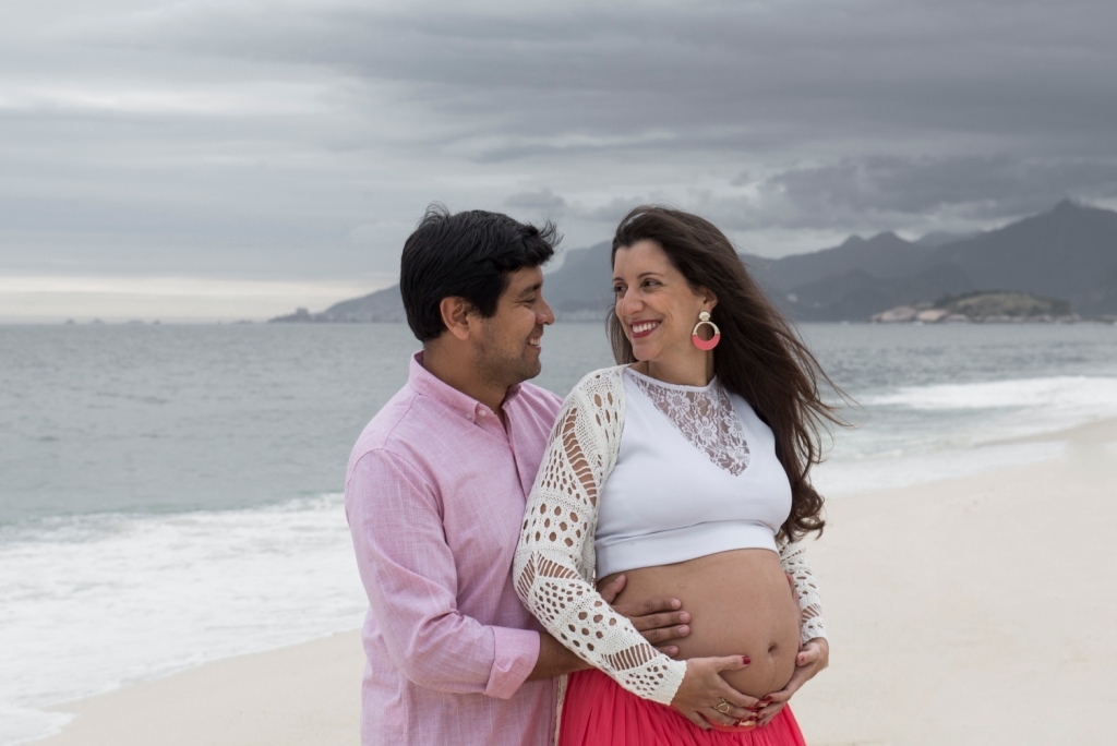 Ensaio fotográfico profissional externo e estúdio de gestante de dia em Niterói Rio de Janeiro na praia de Piratininga em dia chuvoso na areia grávida papai e mamãe com bebê a bordo book de fotos litoral Gilson Freitas fotógrafo vestido e roupa top branco