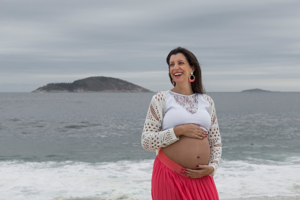 Ensaio fotográfico profissional externo e estúdio de gestante de dia em Niterói Rio de Janeiro na praia de Piratininga em dia chuvoso na areia grávida papai e mamãe com bebê a bordo book de fotos litoral Gilson Freitas fotógrafo vestido e roupa top branco