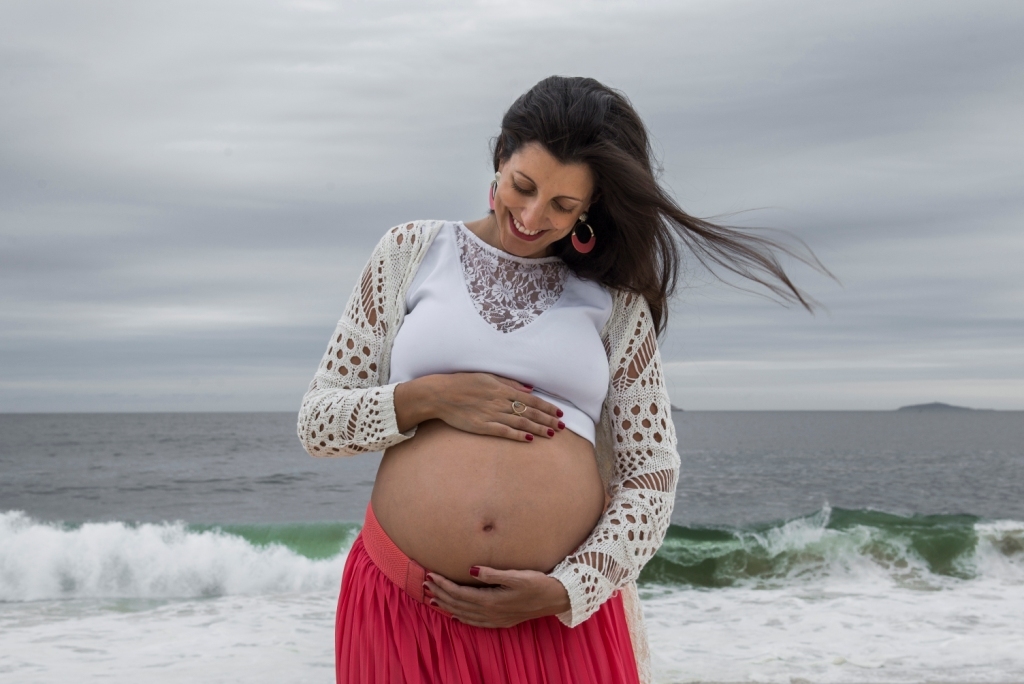 Ensaio fotográfico profissional externo e estúdio de gestante de dia em Niterói Rio de Janeiro na praia de Piratininga em dia chuvoso na areia grávida papai e mamãe com bebê a bordo book de fotos litoral Gilson Freitas fotógrafo vestido e roupa top branco