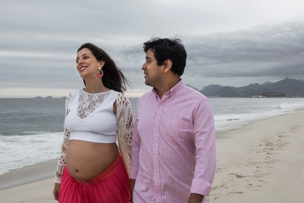 Ensaio fotográfico profissional externo e estúdio de gestante de dia em Niterói Rio de Janeiro na praia de Piratininga em dia chuvoso na areia grávida papai e mamãe com bebê a bordo book de fotos litoral Gilson Freitas fotógrafo vestido e roupa top branco