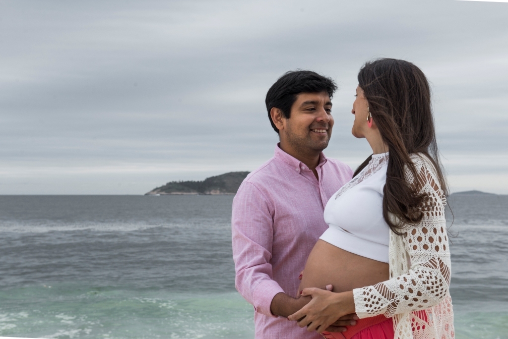 Ensaio fotográfico profissional externo e estúdio de gestante de dia em Niterói Rio de Janeiro na praia de Piratininga em dia chuvoso na areia grávida papai e mamãe com bebê a bordo book de fotos litoral Gilson Freitas fotógrafo vestido e roupa top branco