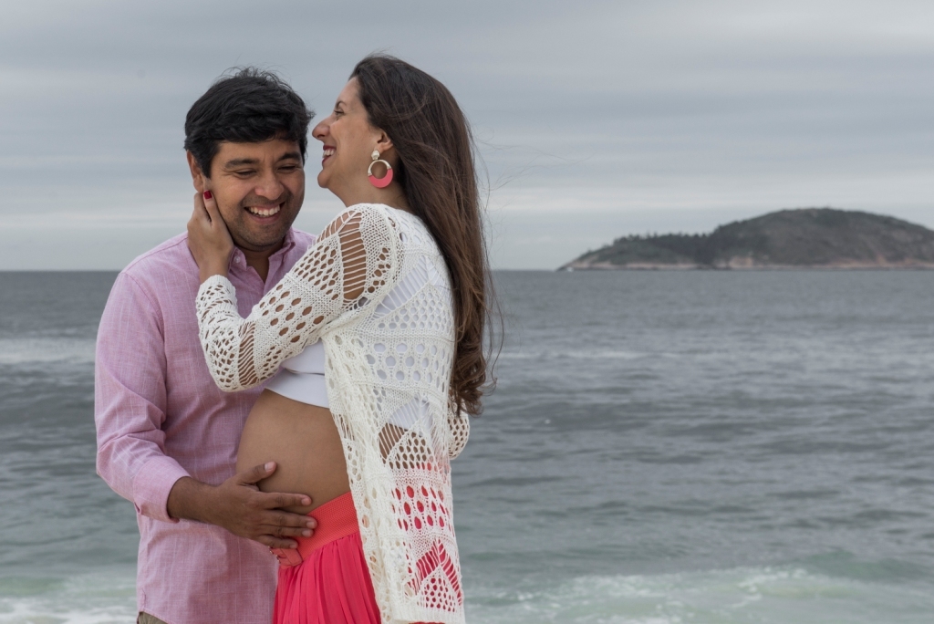 Ensaio fotográfico profissional externo e estúdio de gestante de dia em Niterói Rio de Janeiro na praia de Piratininga em dia chuvoso na areia grávida papai e mamãe com bebê a bordo book de fotos litoral Gilson Freitas fotógrafo vestido e roupa top branco