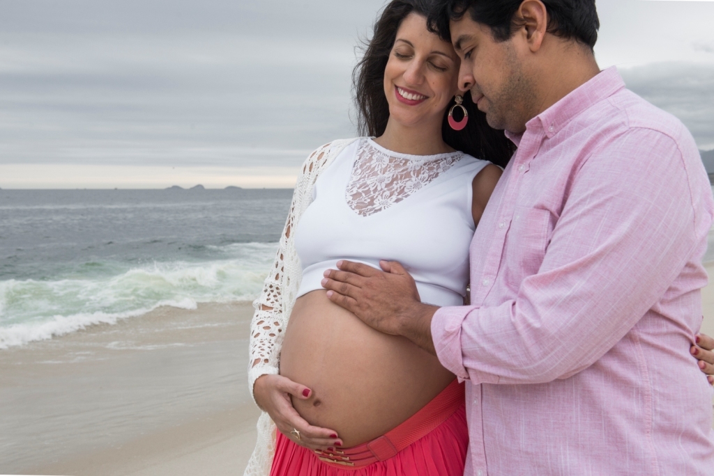 Ensaio fotográfico profissional externo e estúdio de gestante de dia em Niterói Rio de Janeiro na praia de Piratininga em dia chuvoso na areia grávida papai e mamãe com bebê a bordo book de fotos litoral Gilson Freitas fotógrafo vestido e roupa top branco