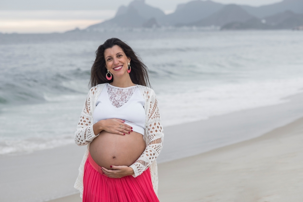 Ensaio fotográfico profissional externo e estúdio de gestante de dia em Niterói Rio de Janeiro na praia de Piratininga em dia chuvoso na areia grávida papai e mamãe com bebê a bordo book de fotos litoral Gilson Freitas fotógrafo vestido e roupa top branco