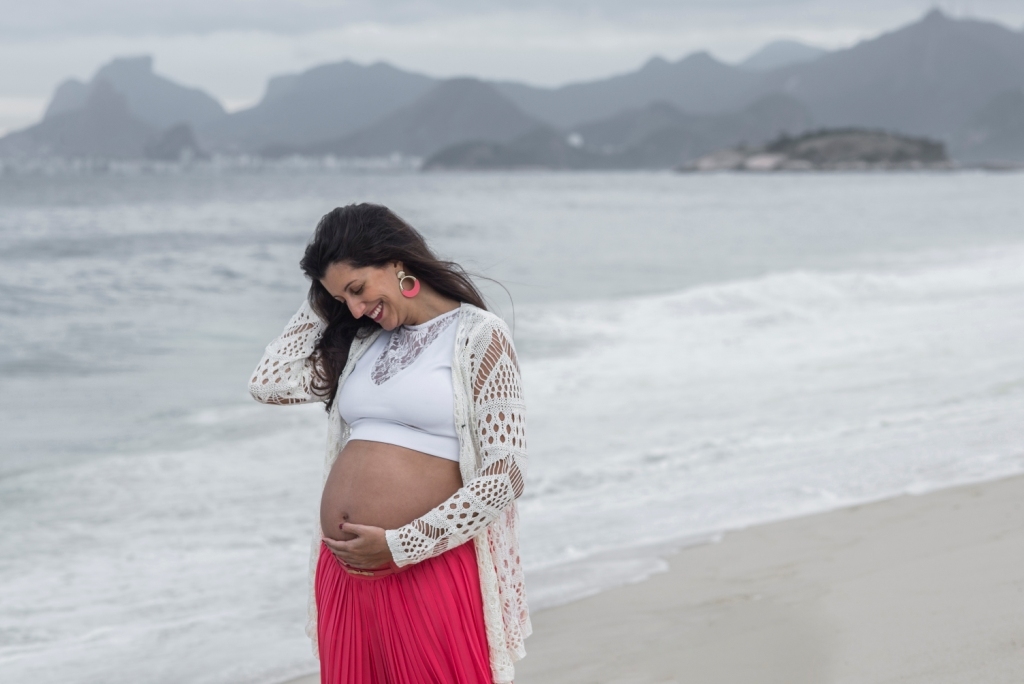 Ensaio fotográfico profissional externo e estúdio de gestante de dia em Niterói Rio de Janeiro na praia de Piratininga em dia chuvoso na areia grávida papai e mamãe com bebê a bordo book de fotos litoral Gilson Freitas fotógrafo vestido e roupa top branco