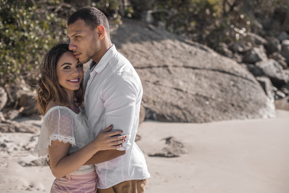 Melhor fotógrafo Nossa Casa Estúdio ensaio fotográfico profissional de casal na cidade de Niterói Rio de janeiro para pré wedding e casamento na praia de adão e eva ao por do sol na areia e mar com noivos/namorados vestidos de branco. Maquiagem noiva