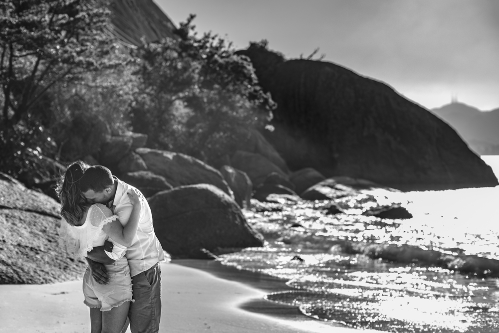 Melhor fotógrafo Nossa Casa Estúdio ensaio fotográfico profissional de casal na cidade de Niterói Rio de janeiro para pré wedding e casamento na praia de adão e eva ao por do sol na areia e mar com noivos/namorados vestidos de branco. Maquiagem noiva