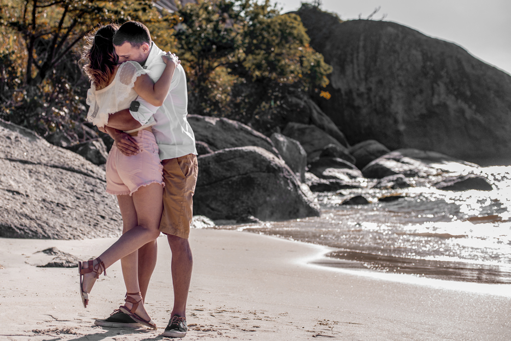 Melhor fotógrafo Nossa Casa Estúdio ensaio fotográfico profissional de casal na cidade de Niterói Rio de janeiro para pré wedding e casamento na praia de adão e eva ao por do sol na areia e mar com noivos/namorados vestidos de branco. Maquiagem noiva