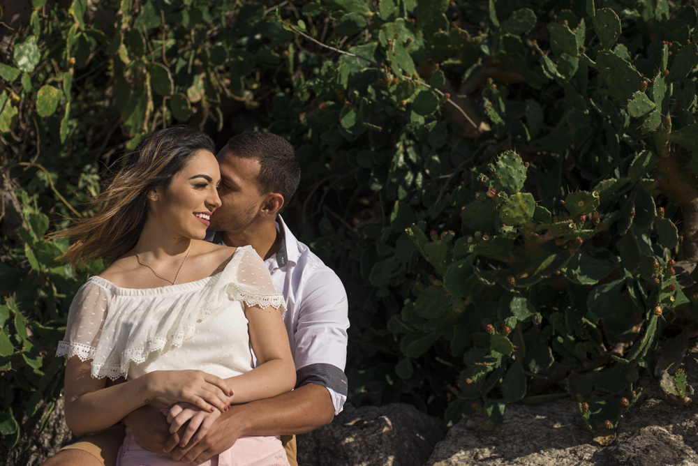 Melhor fotógrafo Nossa Casa Estúdio ensaio fotográfico profissional de casal na cidade de Niterói Rio de janeiro para pré wedding e casamento na praia de adão e eva ao por do sol na areia e mar com noivos/namorados vestidos de branco. Maquiagem noiva