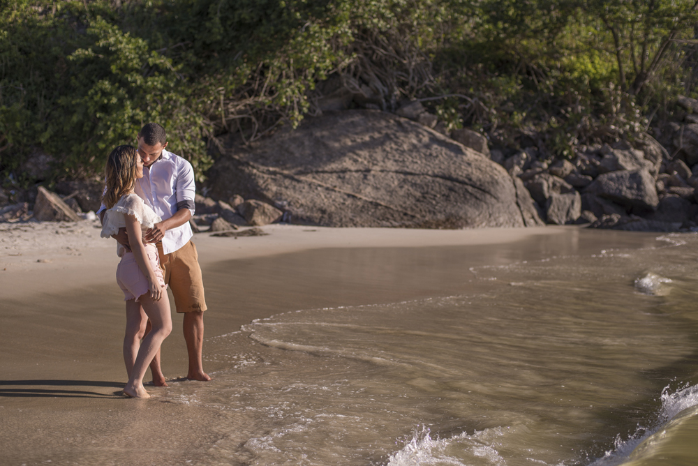 Melhor fotógrafo Nossa Casa Estúdio ensaio fotográfico profissional de casal na cidade de Niterói Rio de janeiro para pré wedding e casamento na praia de adão e eva ao por do sol na areia e mar com noivos/namorados vestidos de branco. Maquiagem noiva