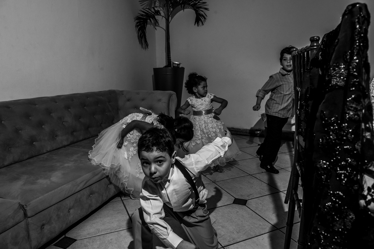 crianças brincando e pulando de vestido branco pulando em sofá na decoração da festa de casamento pista de dança ao som do dj a noite fotografia de casamento criatividade no rio de janeiro solar imperial em Niterói 