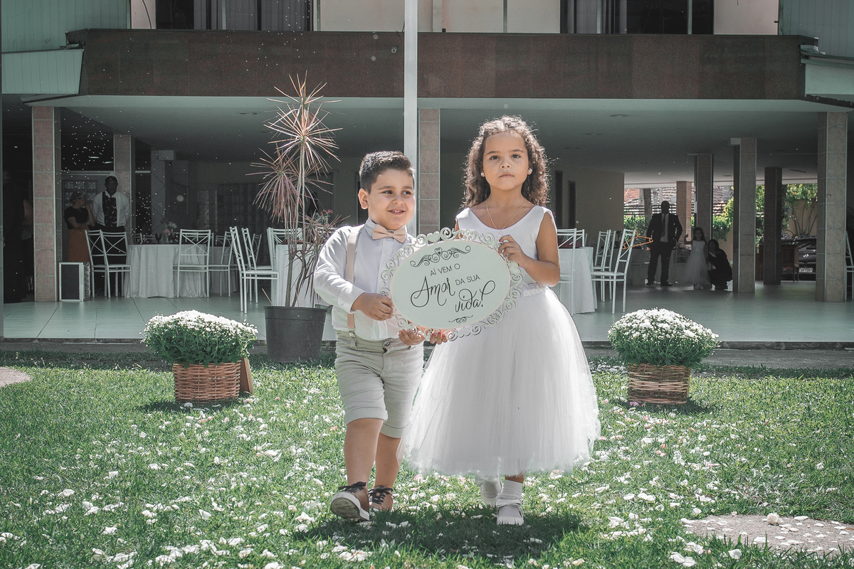 Fotografia de Casamento fotógrafo em Niterói São Gonçalo Rio de Janeiro Maricá cerimônia rústico romântico daminha de honra e pagem entrando com placa da noiva jardim Nossa casa Estúdio fotografia profissional vestido branco e terninho