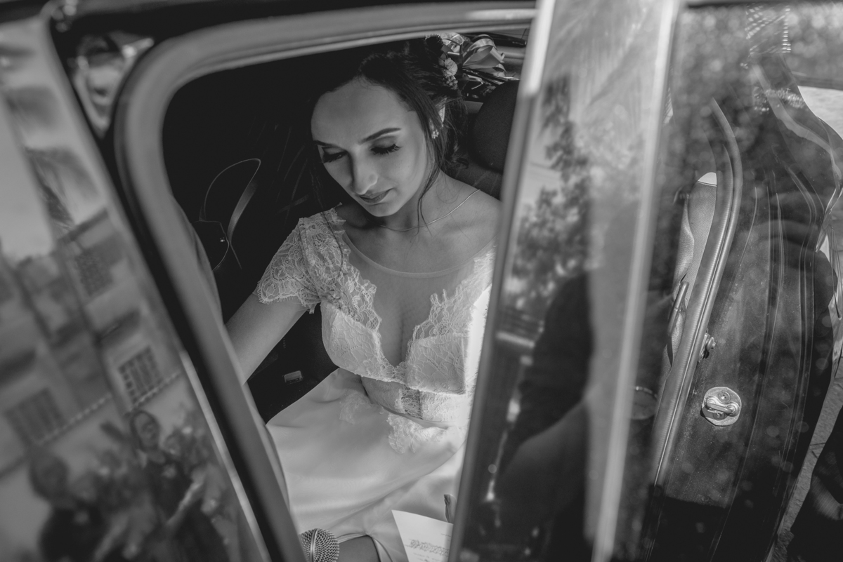 Fotografia de casamento em Niterói São Gonçalo Rio de Janeiro Maricá fotógrafo Noiva chegando no carro preto na cerimônia de casamento com vestido branco e buque de flores pai da noiva Nossa Casa Estúdio