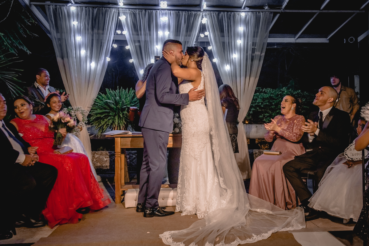 Nossa Casa Estúdio, fotografia profissional de casamentos em Niterói Rio de Janeiro casal de noivos em cerimônia religiosa antes da recepção com família e amigos Noiva de vestido branco e noivo de terno azul emoção chorando alegria buquê de flores beijo