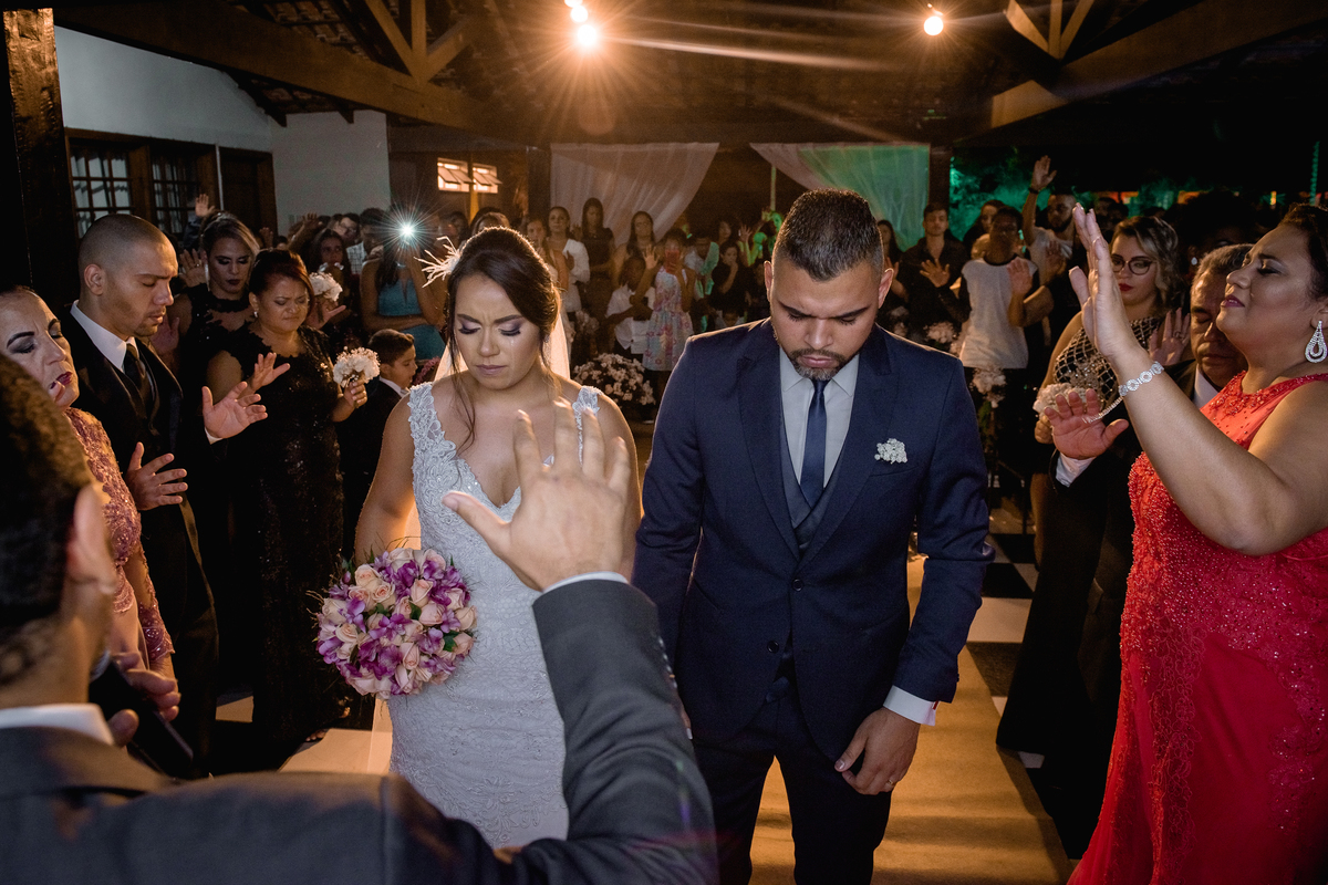 Nossa Casa Estúdio, fotografia profissional de casamentos em Niterói Rio de Janeiro casal de noivos em cerimônia religiosa antes da recepção com família e amigos Noiva de vestido branco e noivo de terno azul emoção chorando alegria buquê de flores