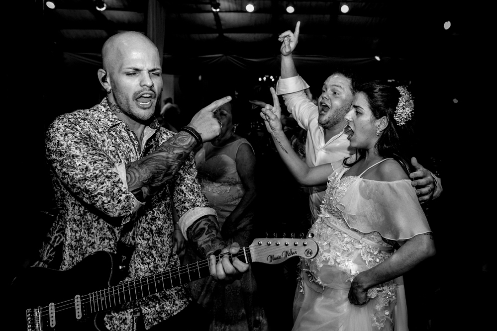 Nossa Casa Estúdio Fotografia de casamento em Niterói Rio de Janeiro e Maricá com noivos em pista de dança fotos criativas e espontâneas no ano de 2019 e 2020 com vestido branco e noivo com terno dançando e banda com música em recanto dos coqueiros 