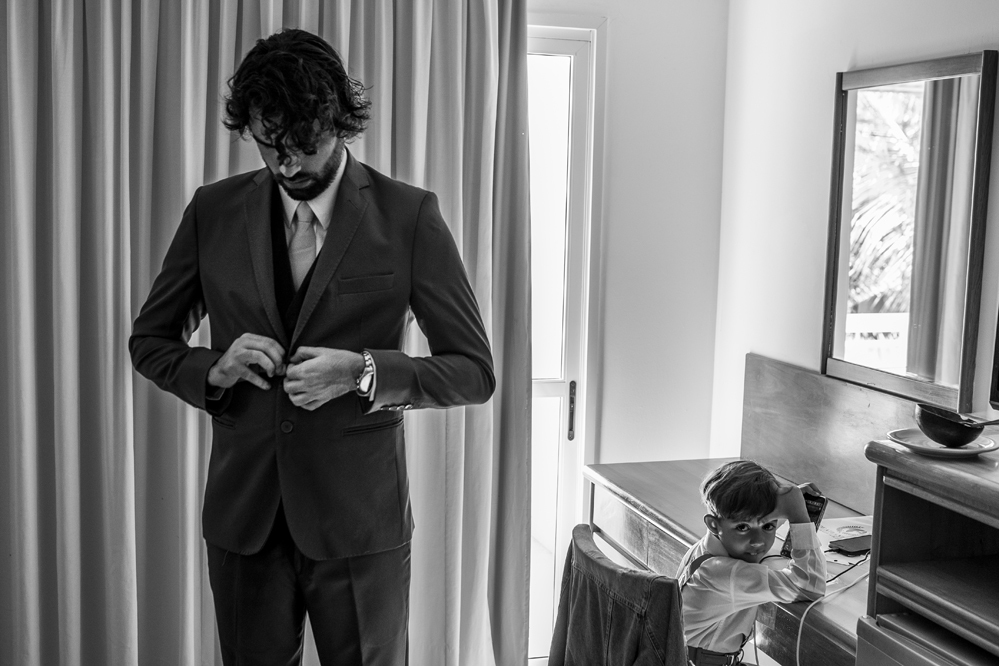 Hotel Atlântico Búzios Nossa Casa Estúdio fotografia de casamento em Niterói Rio de Janeiro Búzios Cabo Frio making of do noivo colocando terno e gravata com sapatos sociais para casamentos com fotógrafo profissional Gilson Freitas cobrindo o evento