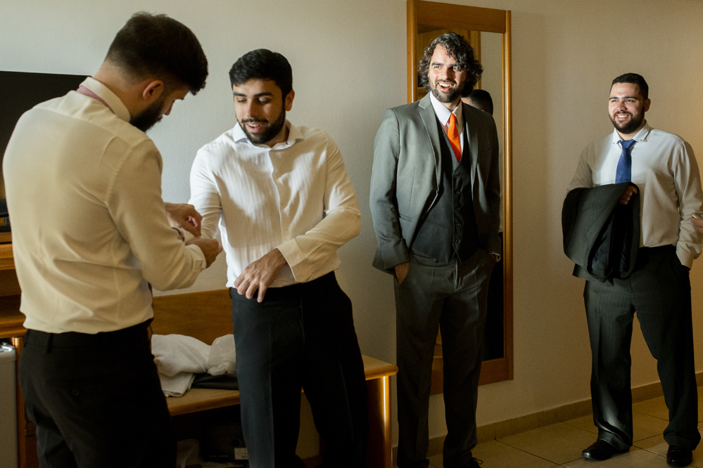Hotel Atlântico Búzios Nossa Casa Estúdio fotografia de casamento em Niterói Rio de Janeiro Búzios Cabo Frio making of do noivo colocando terno e gravata com sapatos sociais para casamentos com fotógrafo profissional Gilson Freitas cobrindo o evento