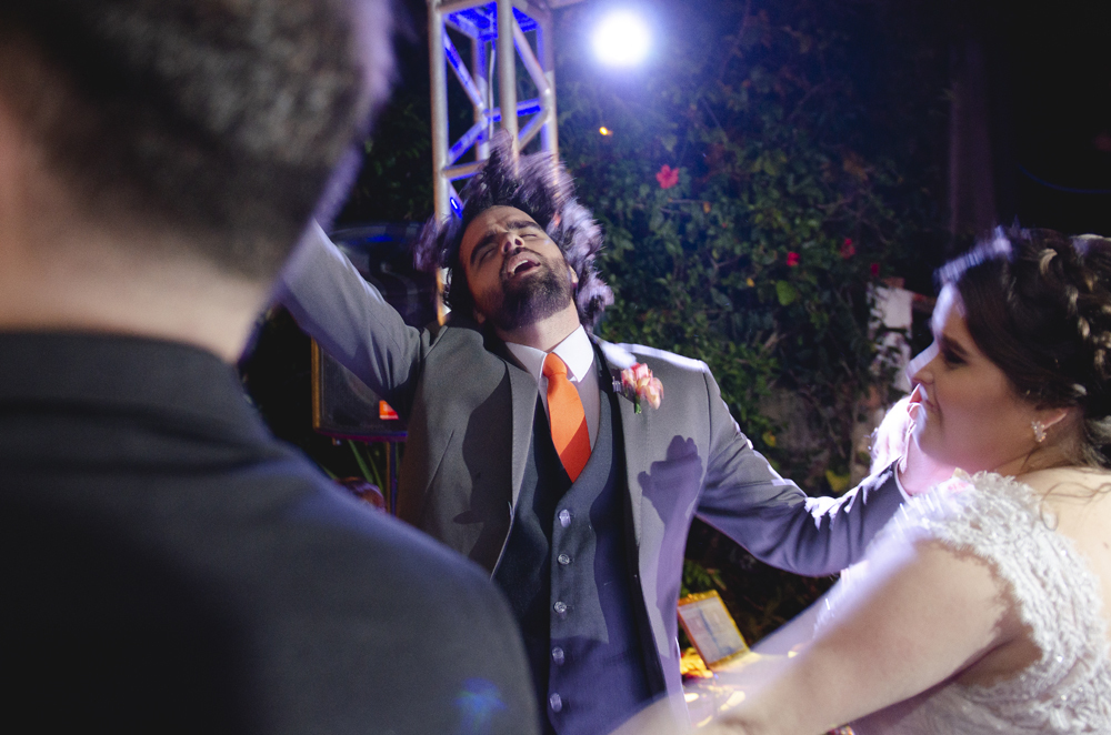 Nossa Casa Estúdio Fotografia profissional de casamento em Niterói Búzios Cabo Frio Rio de Janeiro em Hotel Atlântico Búzios casal de noivos dançando com vestido branco e terno com padrinhos madrinhas e convidados assistindo em festa na pista de dança