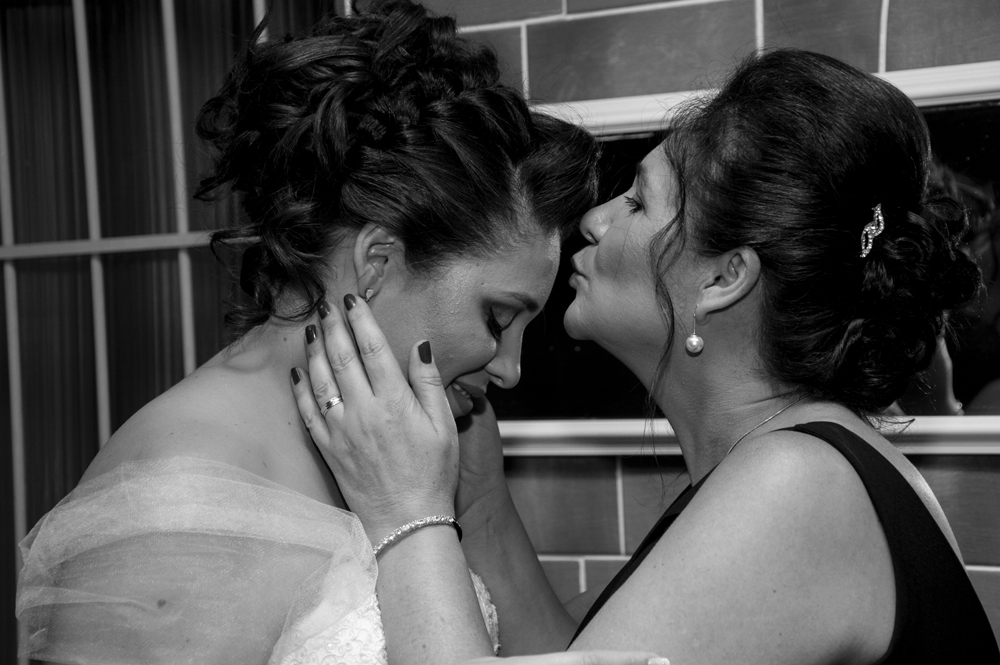 Nossa Casa Estúdio Mãe beijando a noiva em dia do casamento fotografia fotógrafo de casamento vestido branco 
