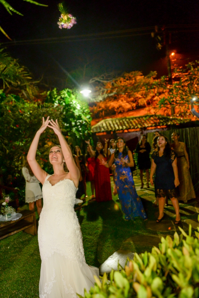 Fotografia de casamento em buzios rio de janeiro pousada da cyssa inesquecível casamento zankyou wedding fotógrafo estilo rústico noiva jogando buque para madrinhas com vestido branco em festa de casamento 
