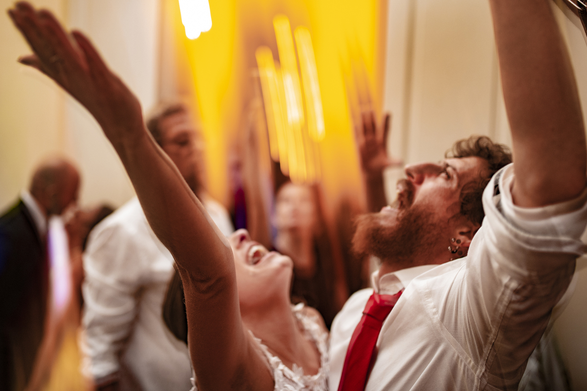 Casal de noivos dançando na pista de dança em dia do casamento com vestido branco e camisa para o noivo em Solar das Palmeiras no bairro de Botafogo 