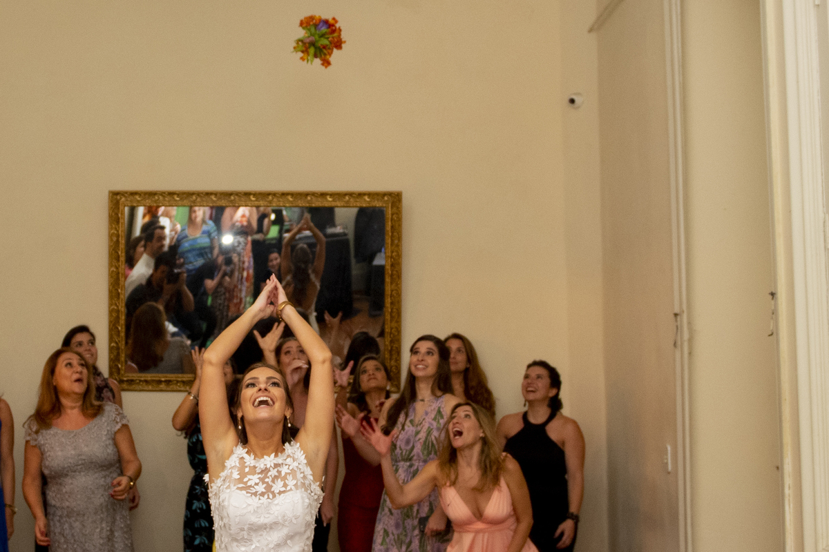 Casal de noivos dançando na pista de dança em dia do casamento com vestido branco e camisa para o noivo em Solar das Palmeiras no bairro de Botafogo convidados no momento do buque da noiva