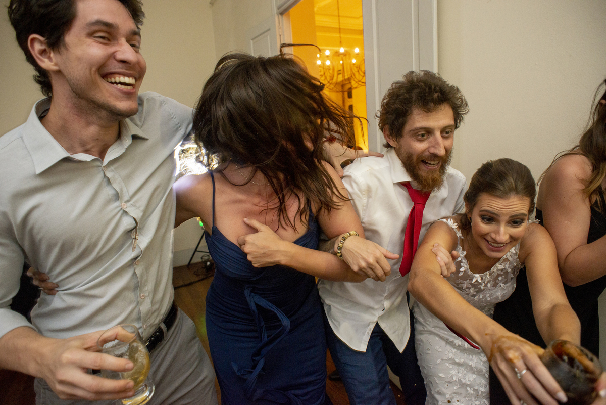 Casal de noivos dançando na pista de dança em dia do casamento com vestido branco e camisa para o noivo em Solar das Palmeiras no bairro de Botafogo convidados madrinhas e padrinhos dançando  roupa para eles