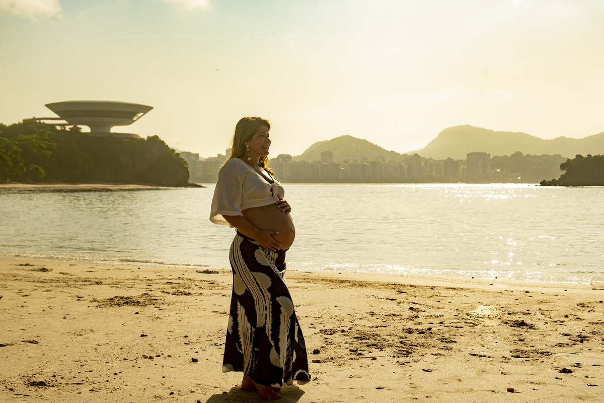 nossa casa estúdio fotógrafo de gestante em niterói e rio de janeiro ensaio externo praia mamães mães 2020 2021 fotografia para gestantes baby bebês zona sul ensaio nascer do sol lugar paradisíaco roupas gestante inspiração fotografia mac museu